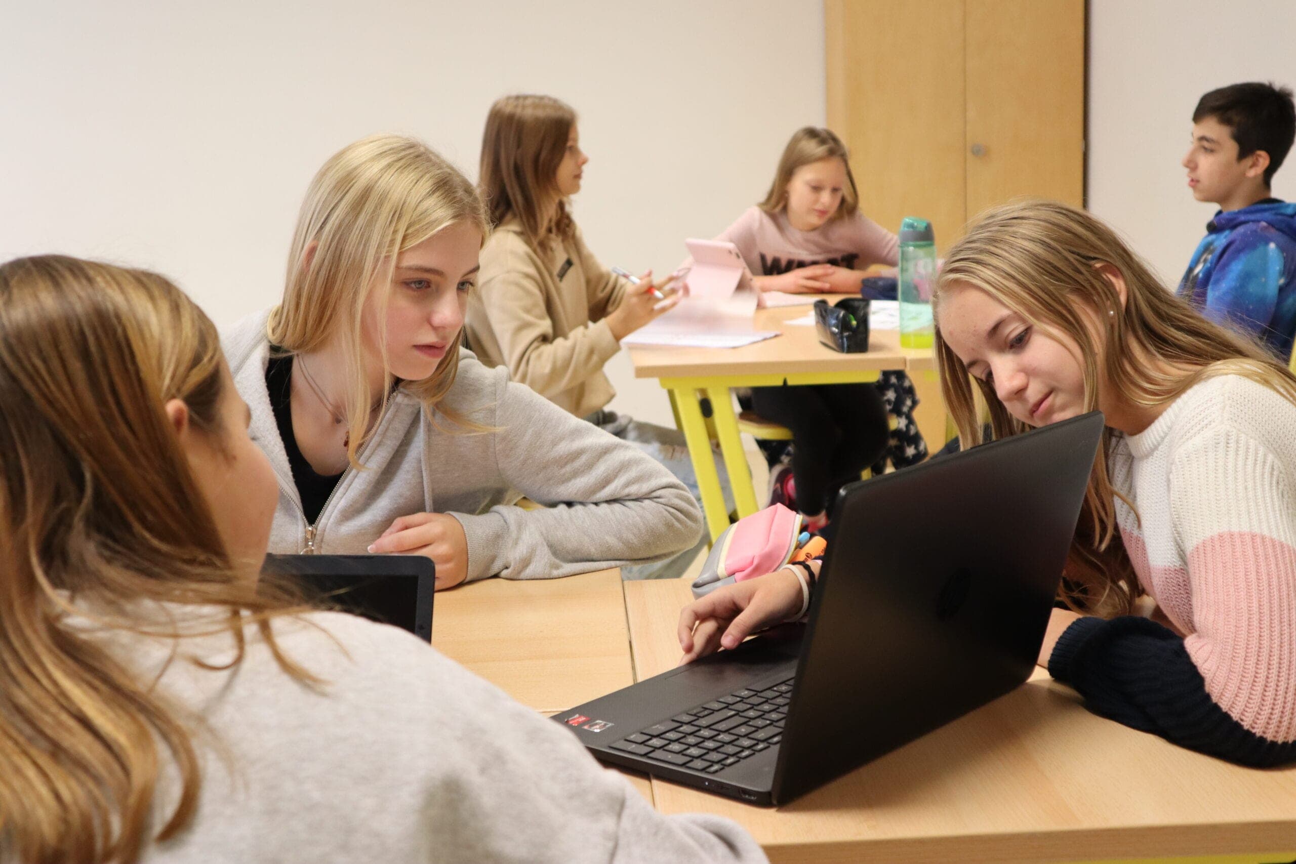 Schülerinnen der wikawi arbeiten gemeinsam an Laptops im Unterricht